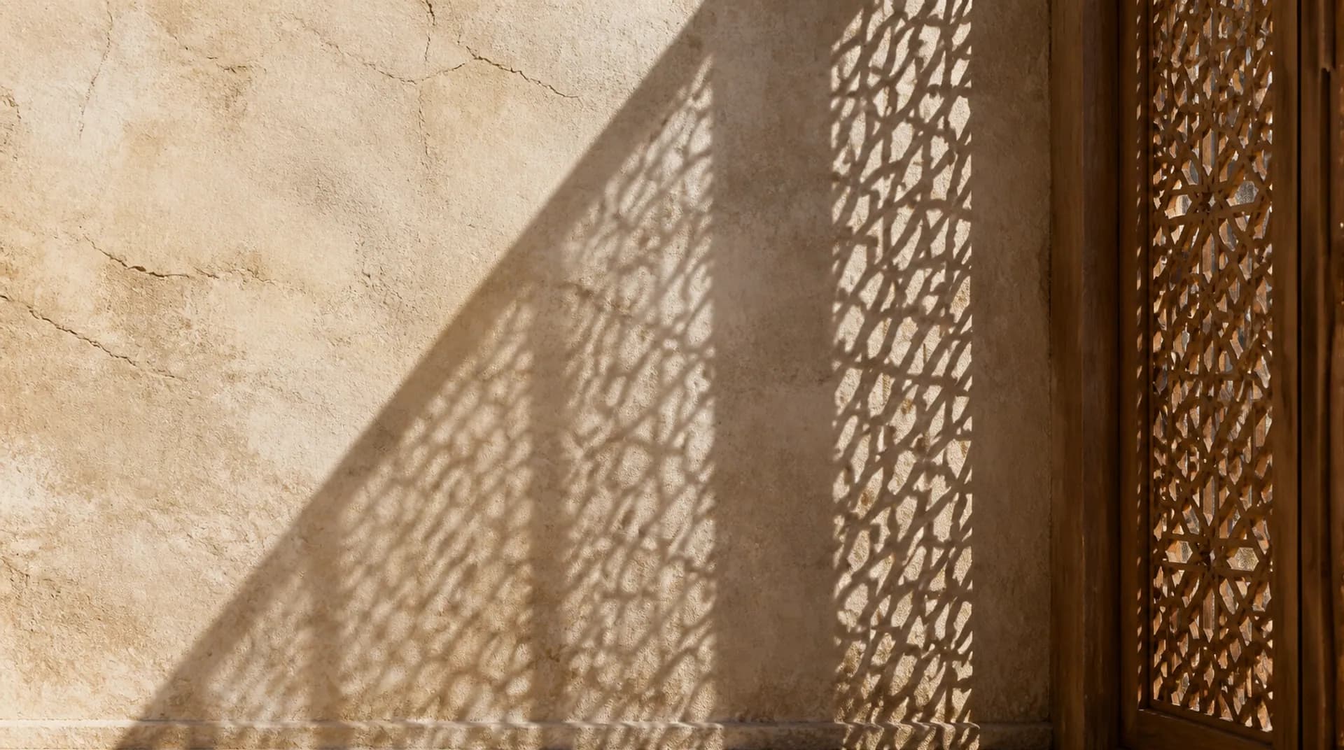 ظل مشربية على جدار جصّي مع خط ظل أبهت من وقت سابق.